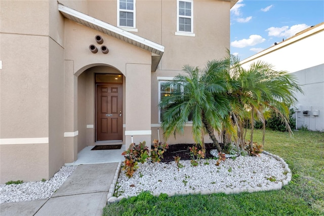 entrance to property with a lawn