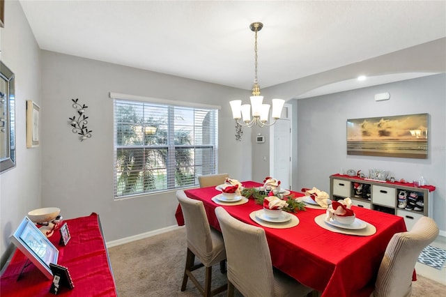 dining room with carpet flooring and an inviting chandelier