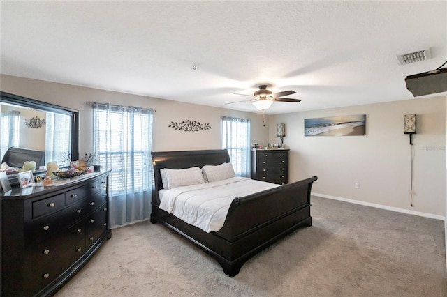 carpeted bedroom featuring a textured ceiling and ceiling fan