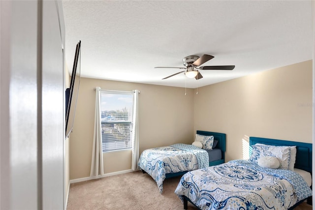 bedroom featuring ceiling fan, light colored carpet, and a textured ceiling