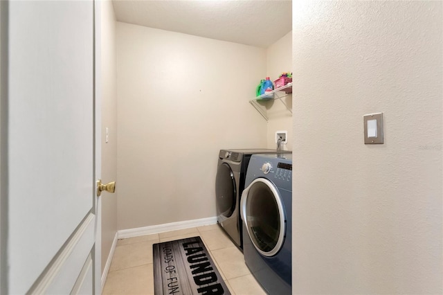 laundry room featuring washer and dryer and light tile patterned flooring