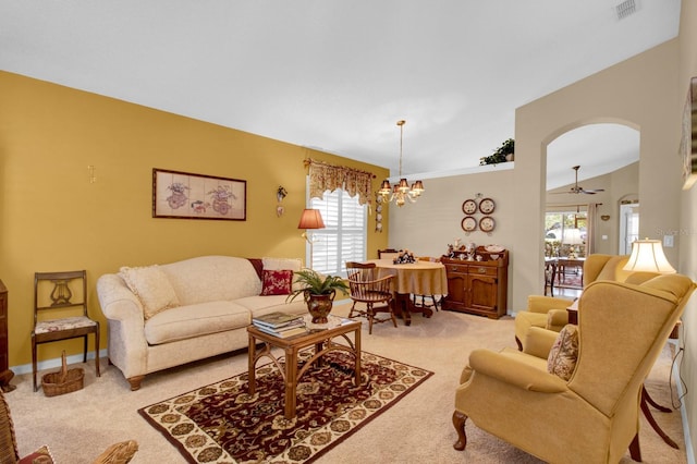 living room with light carpet, a notable chandelier, and vaulted ceiling