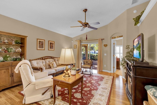 living room featuring ceiling fan, lofted ceiling, a textured ceiling, and light wood-type flooring