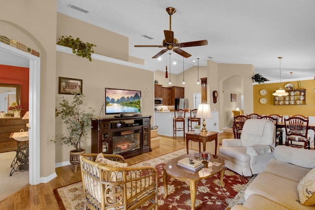 living room featuring ceiling fan, high vaulted ceiling, and light hardwood / wood-style floors