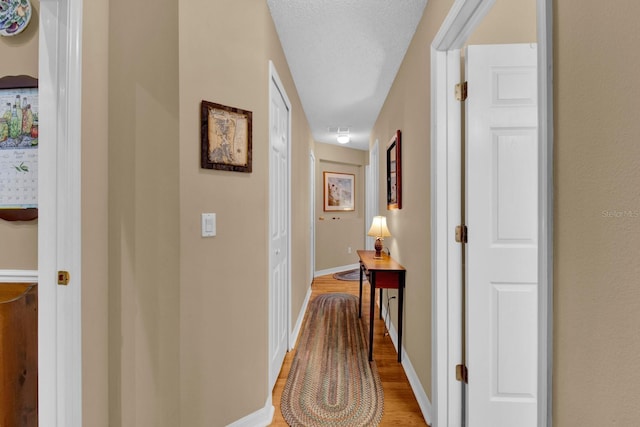 corridor featuring hardwood / wood-style floors and a textured ceiling