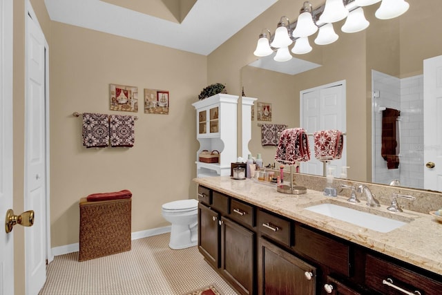 bathroom featuring a tile shower, vanity, tile patterned floors, and toilet