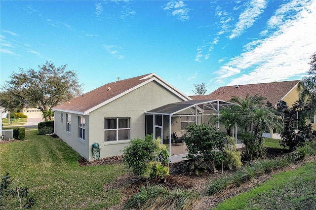 rear view of property with a lanai, central AC unit, and a lawn