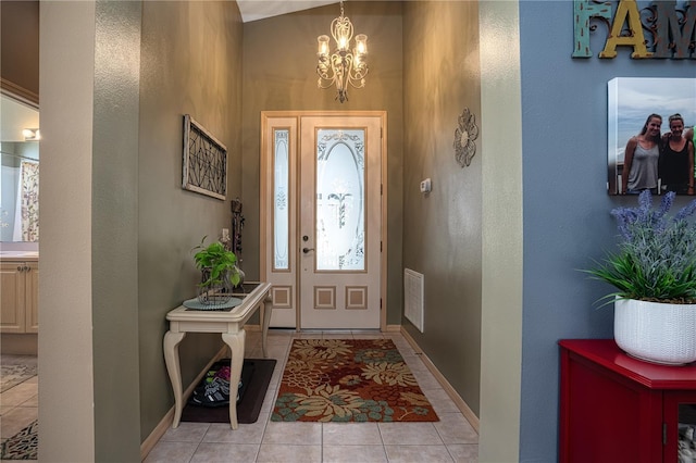 tiled entrance foyer featuring a notable chandelier