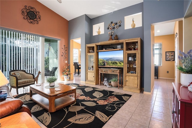 living room with a healthy amount of sunlight, light tile patterned floors, and high vaulted ceiling