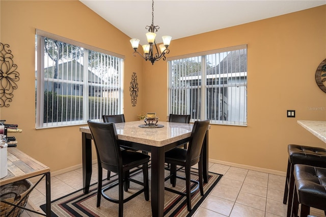 tiled dining area featuring lofted ceiling and an inviting chandelier