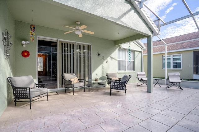 view of patio featuring ceiling fan and glass enclosure