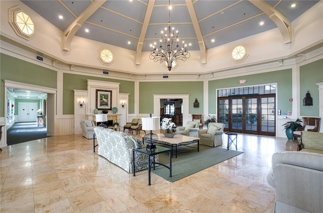 living room featuring a towering ceiling, an inviting chandelier, and french doors