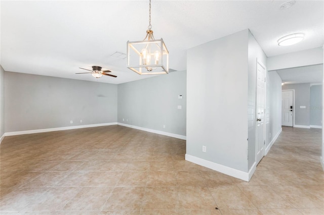 empty room featuring light tile patterned floors and ceiling fan with notable chandelier