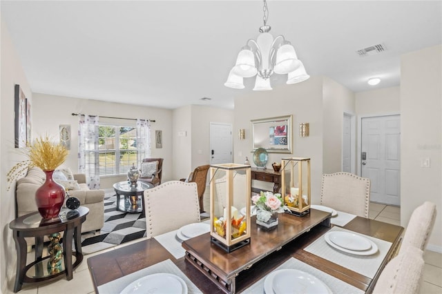 dining room with light tile patterned floors and a chandelier