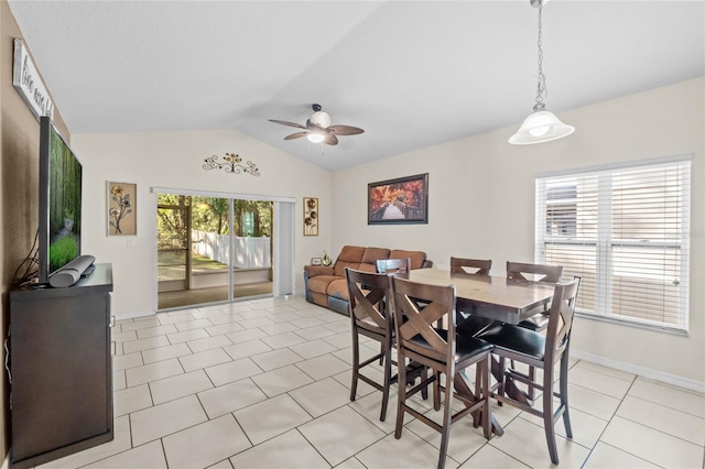 dining area with ceiling fan, vaulted ceiling, and light tile patterned floors