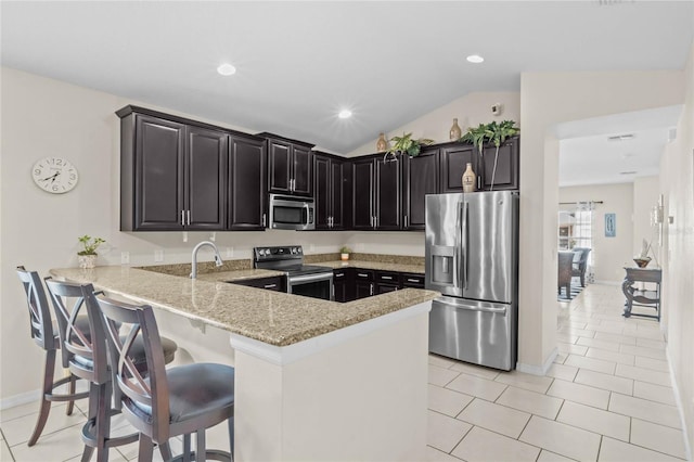 kitchen featuring lofted ceiling, light tile patterned floors, kitchen peninsula, stainless steel appliances, and light stone countertops