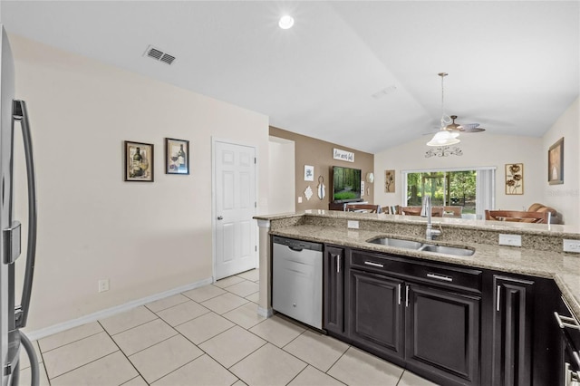 kitchen featuring light tile patterned flooring, lofted ceiling, sink, light stone counters, and stainless steel appliances