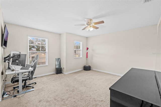 carpeted home office featuring ceiling fan