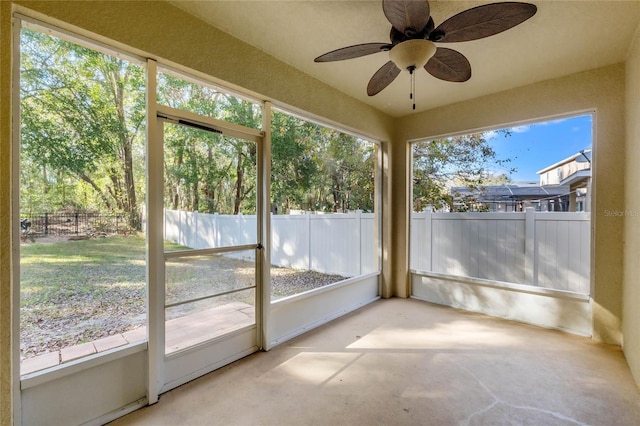 unfurnished sunroom featuring ceiling fan