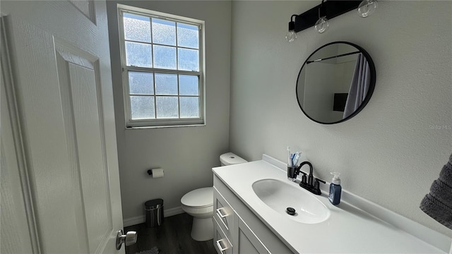 bathroom with hardwood / wood-style flooring, vanity, plenty of natural light, and toilet