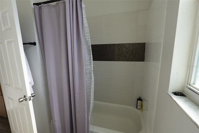 bathroom with shower / bath combo with shower curtain