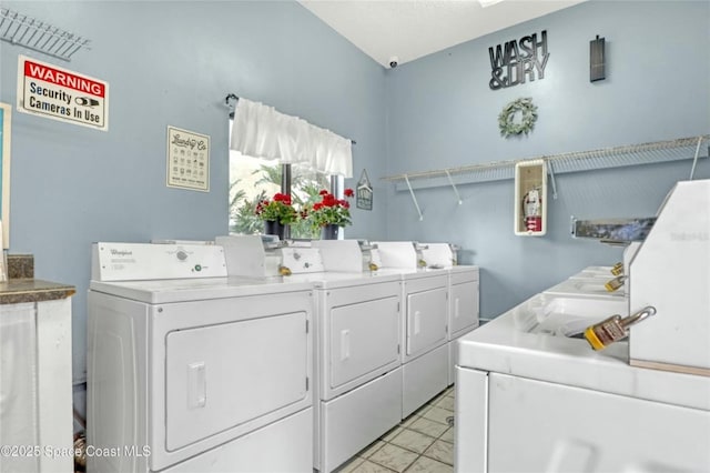 clothes washing area featuring separate washer and dryer and light tile patterned floors