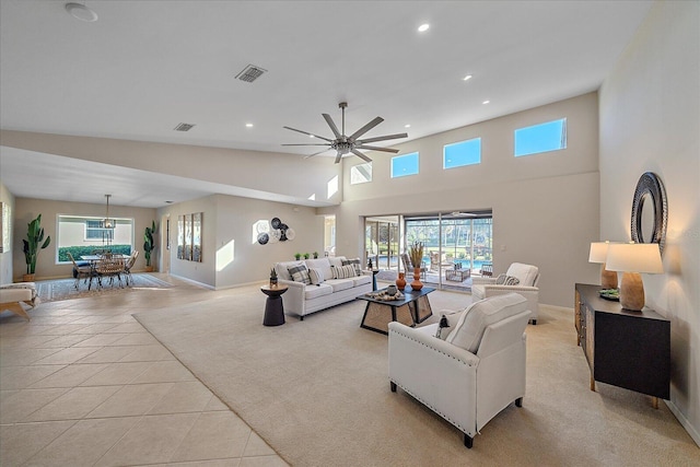 living room with ceiling fan, vaulted ceiling, and light tile patterned floors