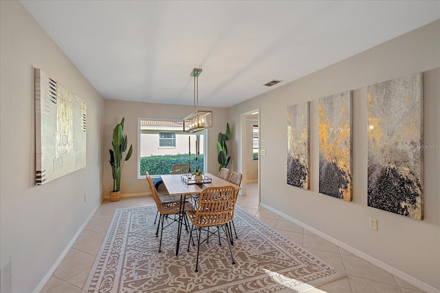 tiled dining room featuring an inviting chandelier