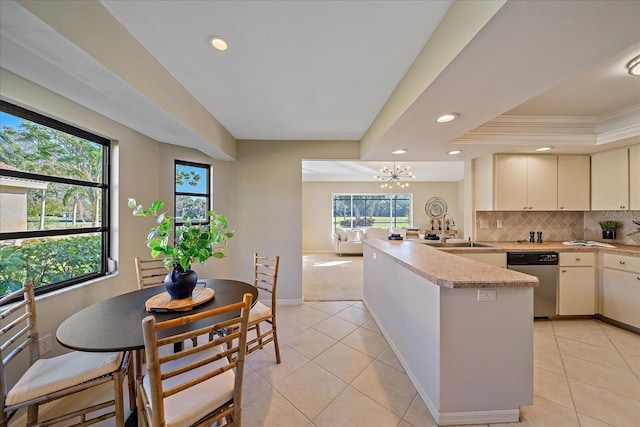 kitchen featuring a raised ceiling, sink, a wealth of natural light, and decorative backsplash