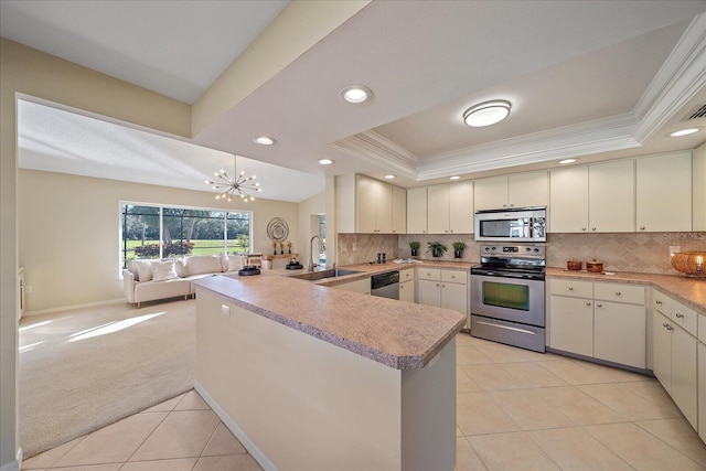 kitchen with light colored carpet, appliances with stainless steel finishes, kitchen peninsula, and sink