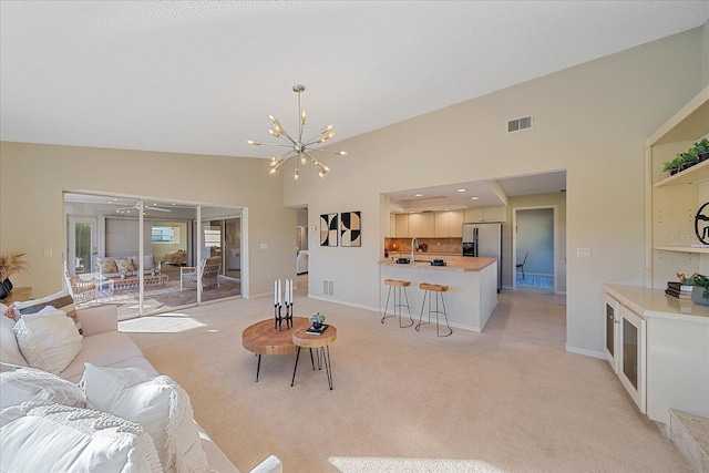 living room featuring light carpet and a chandelier