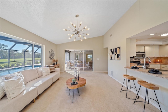 carpeted living room featuring sink, a chandelier, vaulted ceiling, and a textured ceiling