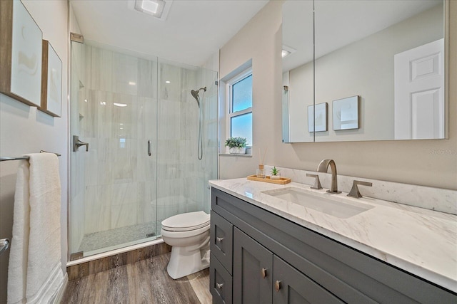 bathroom featuring hardwood / wood-style flooring, vanity, an enclosed shower, and toilet