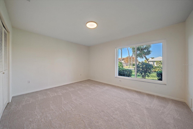 unfurnished bedroom featuring light carpet and a closet