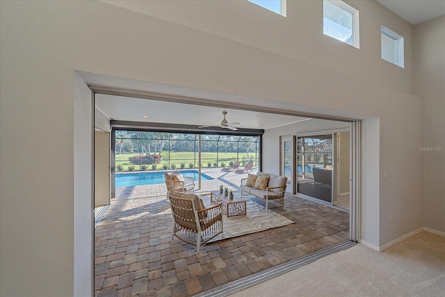 interior space featuring ceiling fan, an indoor pool, and an outdoor living space