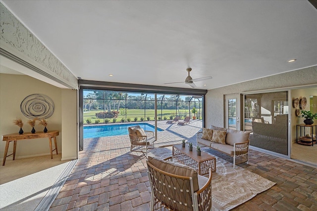 view of patio featuring ceiling fan, outdoor lounge area, and glass enclosure