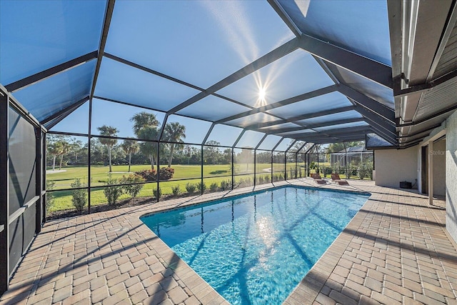 view of swimming pool with a lawn, glass enclosure, and a patio area