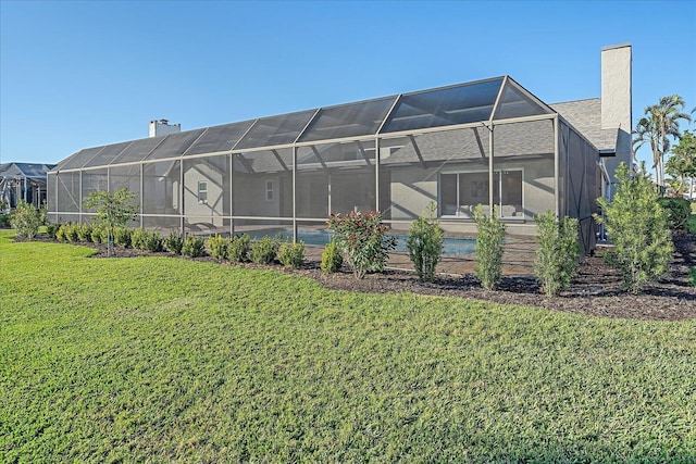 back of property with a yard and a lanai