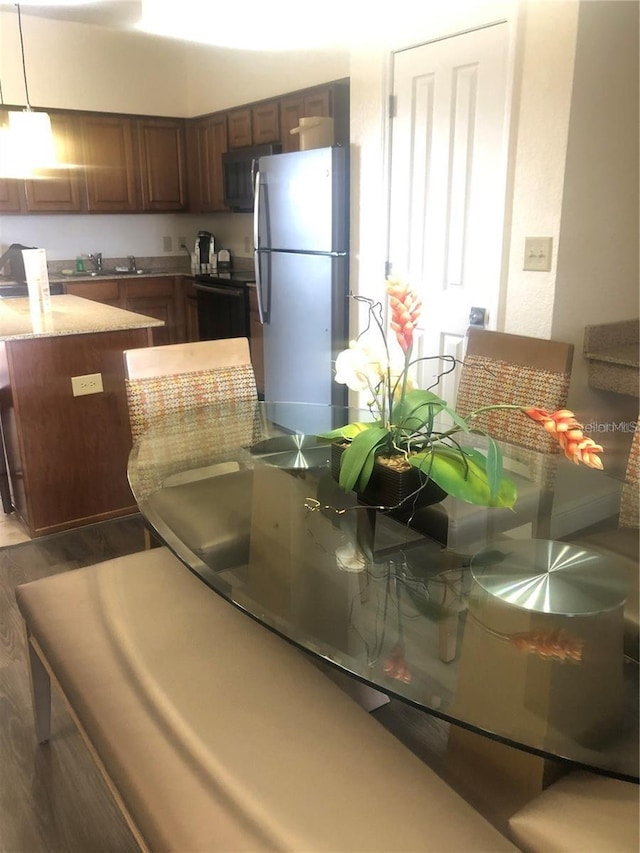 kitchen featuring dishwashing machine, sink, stainless steel fridge, and dark hardwood / wood-style flooring