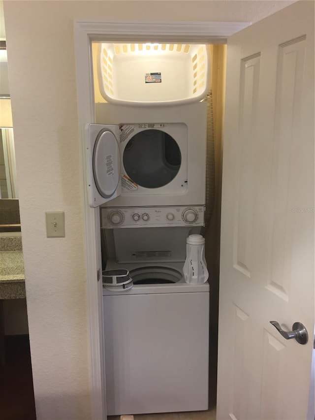 clothes washing area with stacked washer and dryer