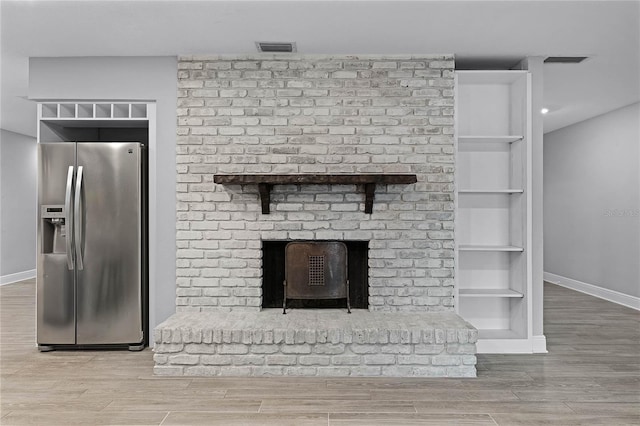 room details featuring stainless steel fridge and wood-type flooring