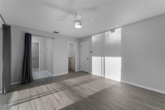 spare room with ceiling fan, wood-type flooring, and a textured ceiling