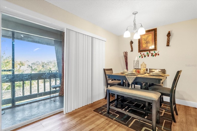 dining room with an inviting chandelier, a wealth of natural light, and light wood-type flooring