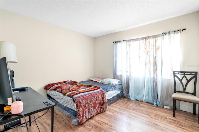 bedroom featuring a textured ceiling and light wood-type flooring