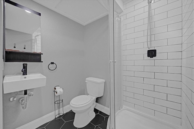 bathroom featuring tile patterned flooring, sink, toilet, and tiled shower