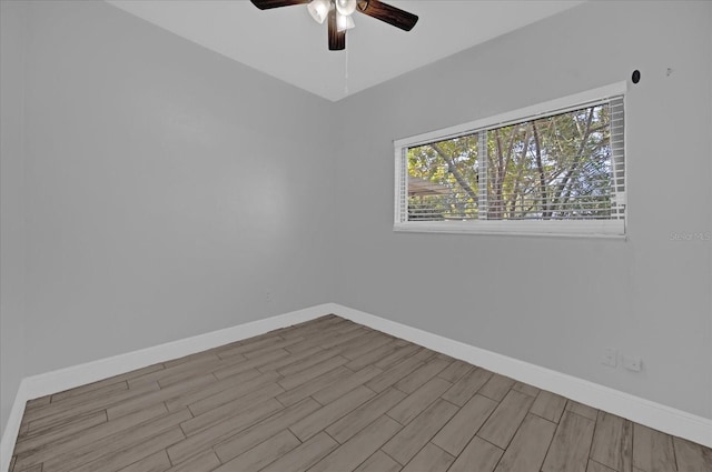 spare room featuring ceiling fan, a healthy amount of sunlight, and light hardwood / wood-style flooring