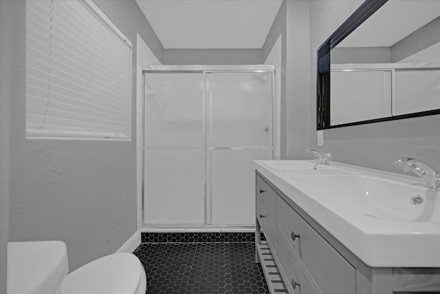 bathroom with vanity, toilet, and a shower with door