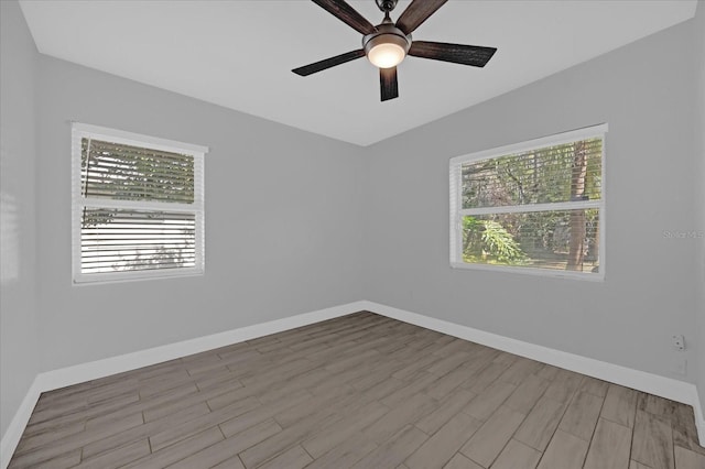 empty room featuring ceiling fan, plenty of natural light, and light hardwood / wood-style floors