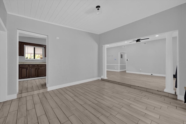 unfurnished living room featuring crown molding, light hardwood / wood-style flooring, ceiling fan, and ornate columns