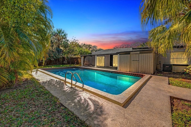 pool at dusk featuring cooling unit